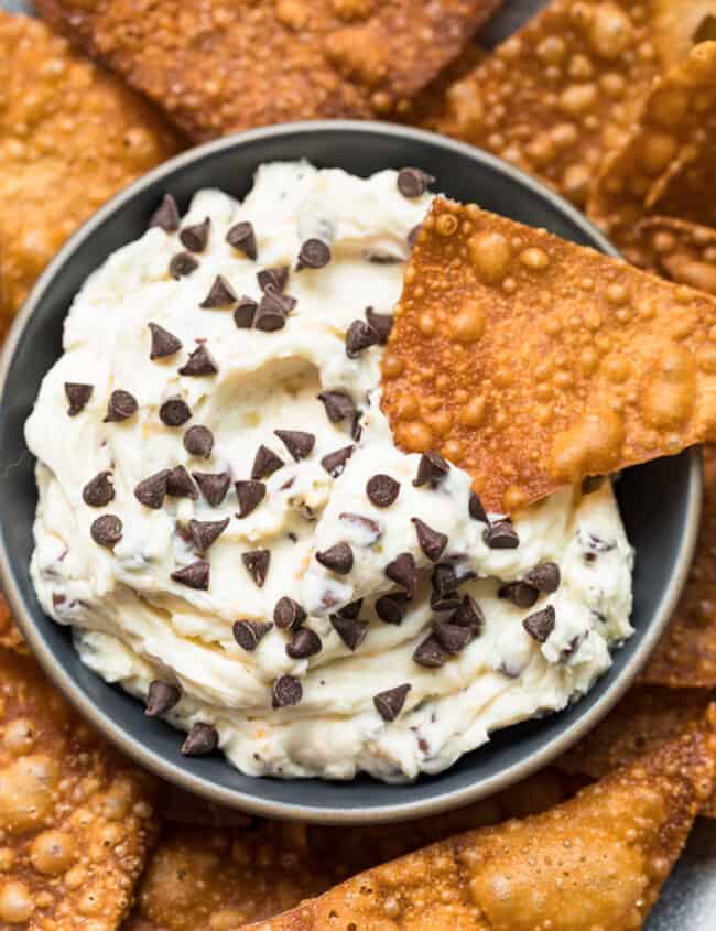 wonton chip dipping in cannoli dip with chocolate chips
