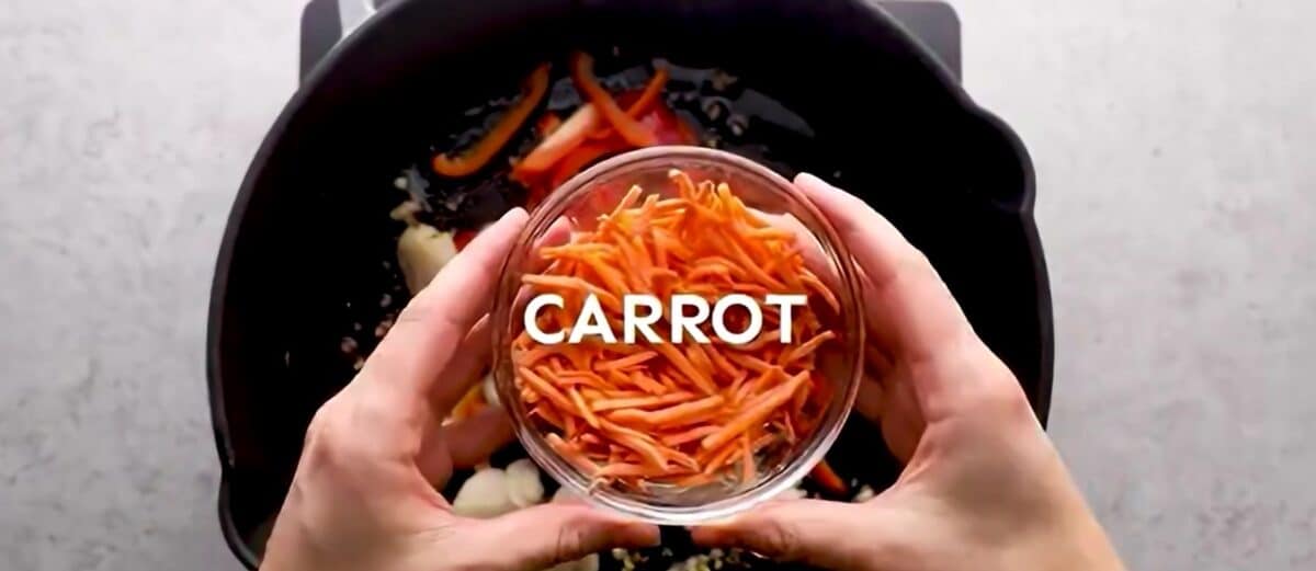 Adding veggies to the skillet.