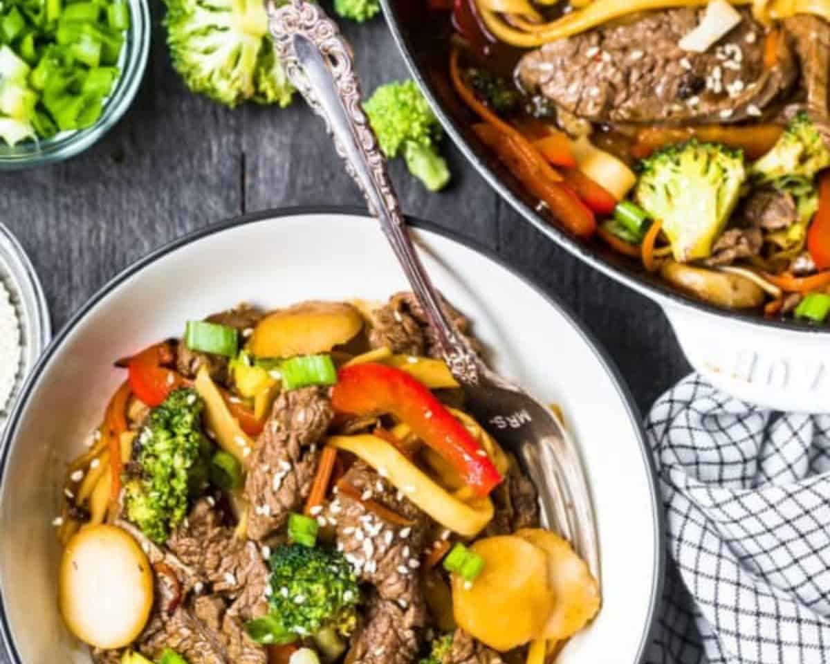 Plate of beef lo mein with a fork.