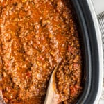 wooden spoon in spaghetti sauce in slow cooker