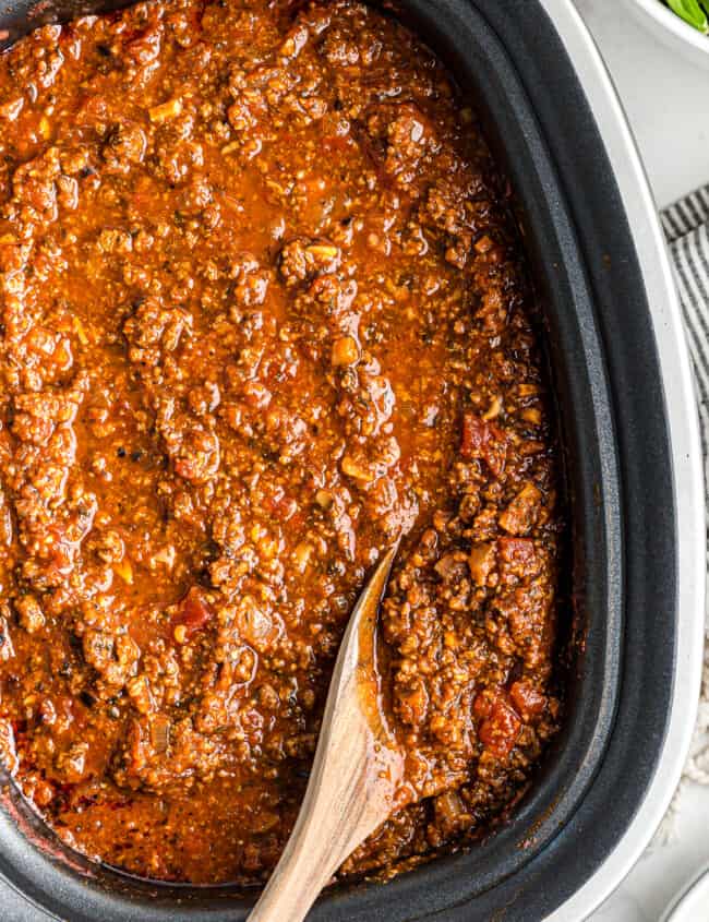 wooden spoon in spaghetti sauce in slow cooker