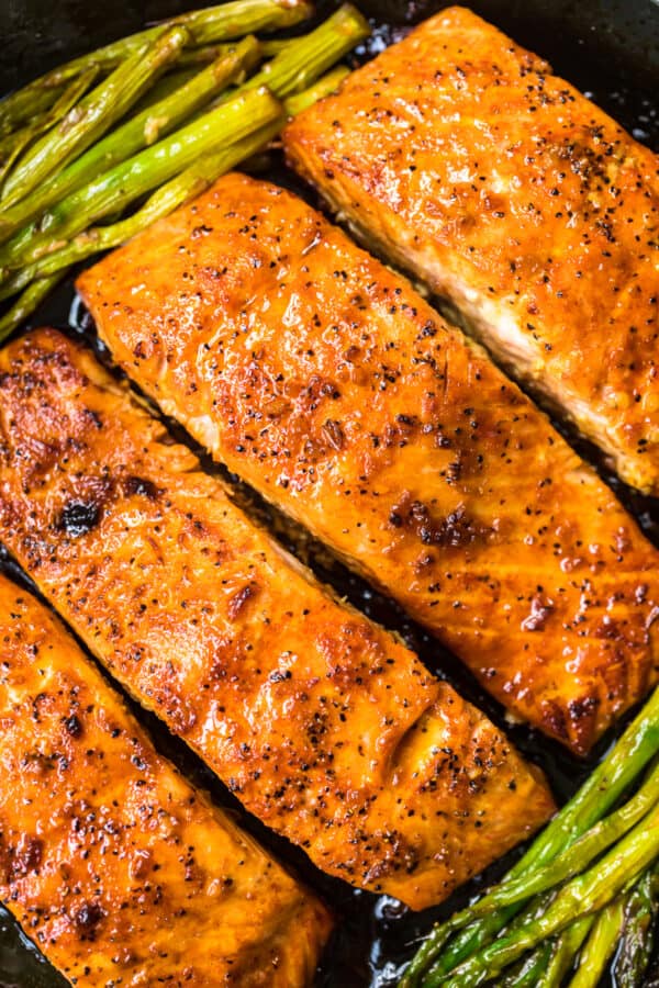 up close honey garlic salmon with asparagus in skillet