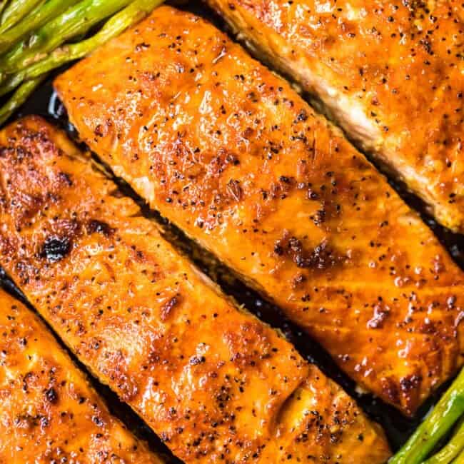 up close honey garlic salmon with asparagus in skillet