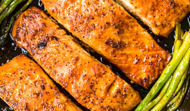 up close honey garlic salmon with asparagus in skillet