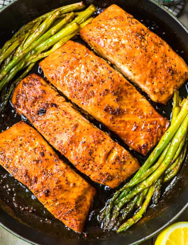 up close honey garlic salmon with asparagus in skillet