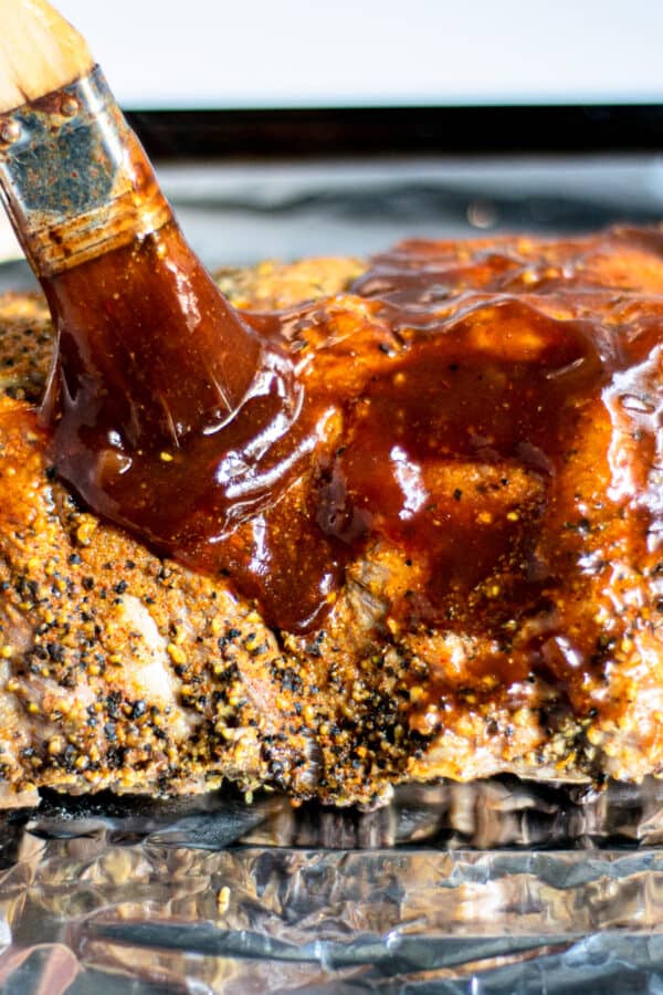 brushing ribs with bbq sauce