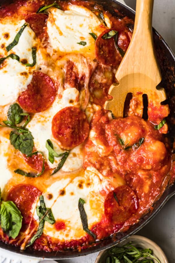 wooden spoon in skillet of pizza gnocchi casserole