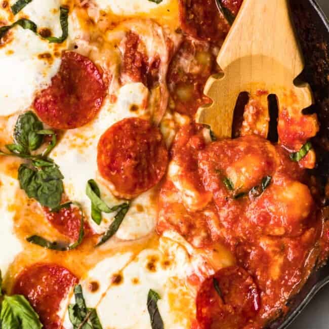 wooden spoon in skillet of pizza gnocchi casserole