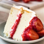 slice of white cake with strawberry filling and whipped cream frosting