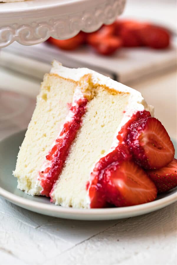 slice of white cake with strawberry filling and whipped cream frosting