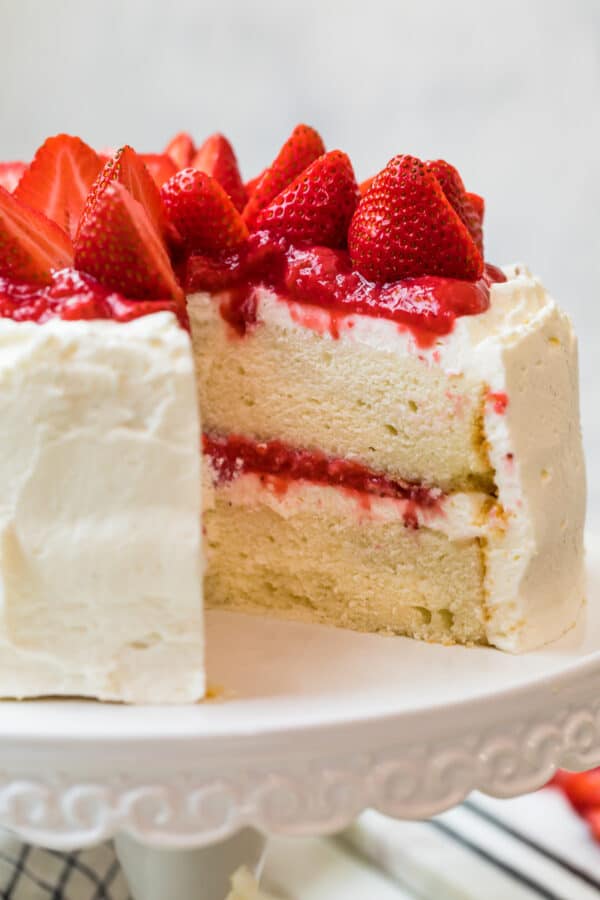 white layer cake with whipped cream frosting and strawberry filling