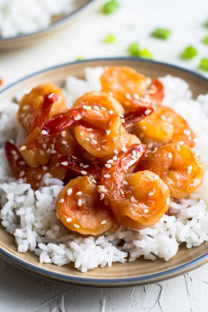 honey sesame shrimp over rice on brown plate