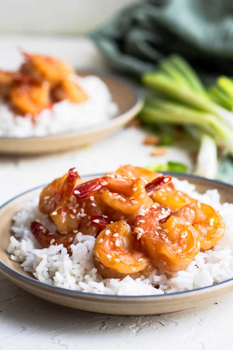 two plates with shrimp, rice, and sesame seeds