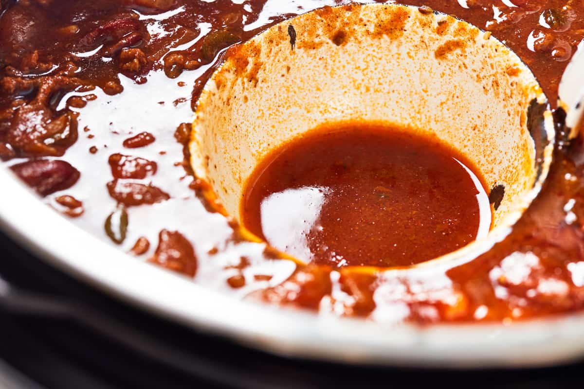 Draining liquid from the instant pot chili.