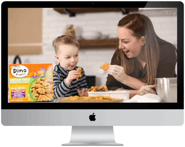 a woman and child eating chicken nuggets on a computer screen.