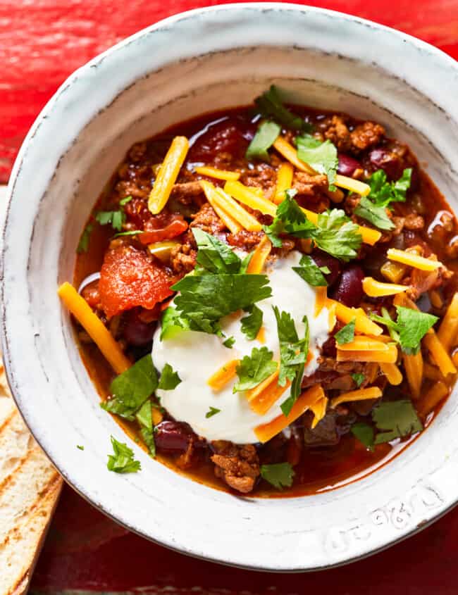 bowl of instant pot chili garnished with cheese and sour cream