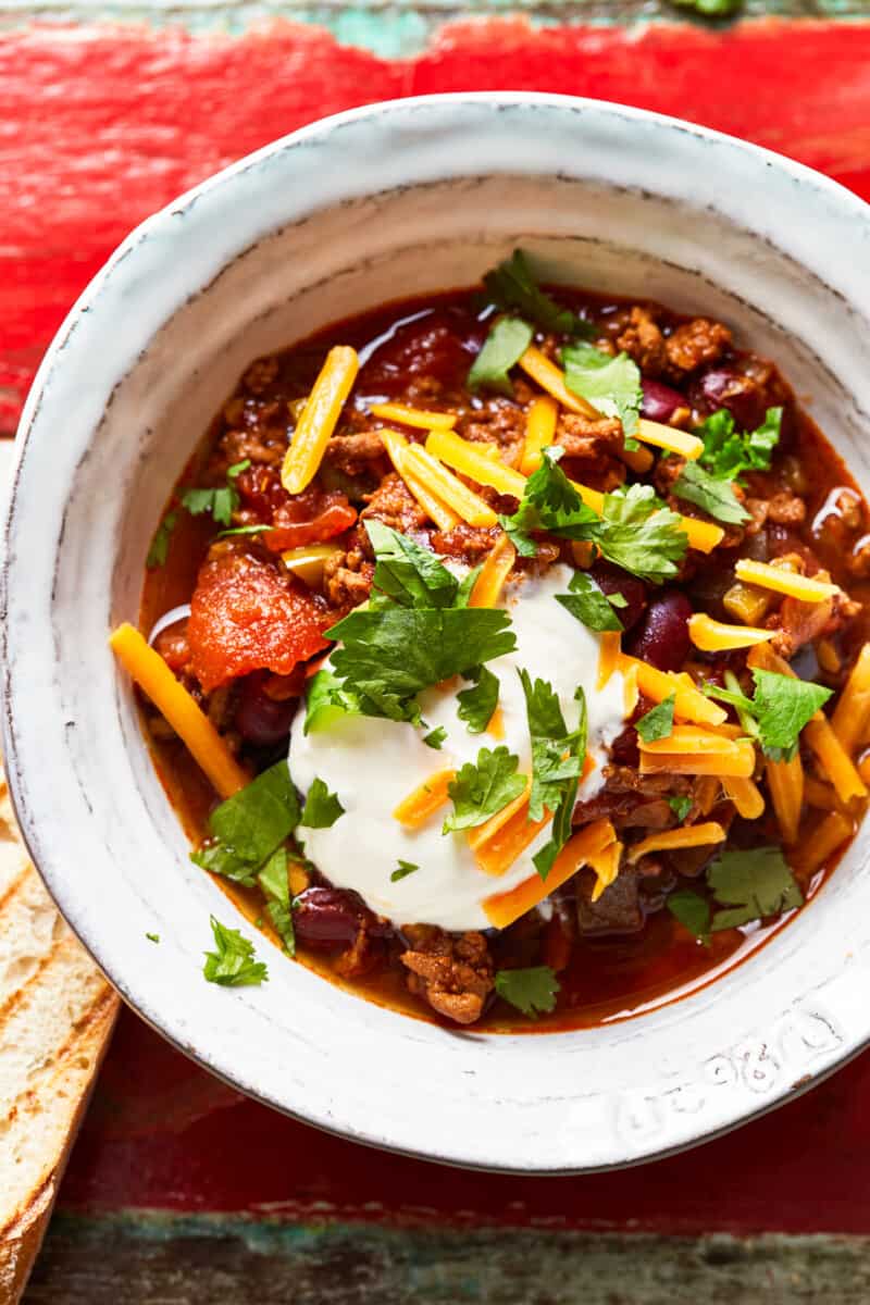 bowl of instant pot chili garnished with cheese and sour cream