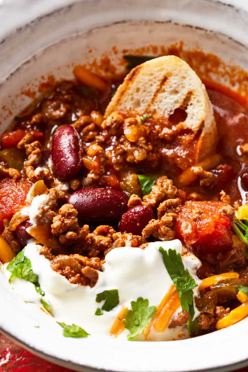 bowl of instant pot chili garnished with cheese and sour cream