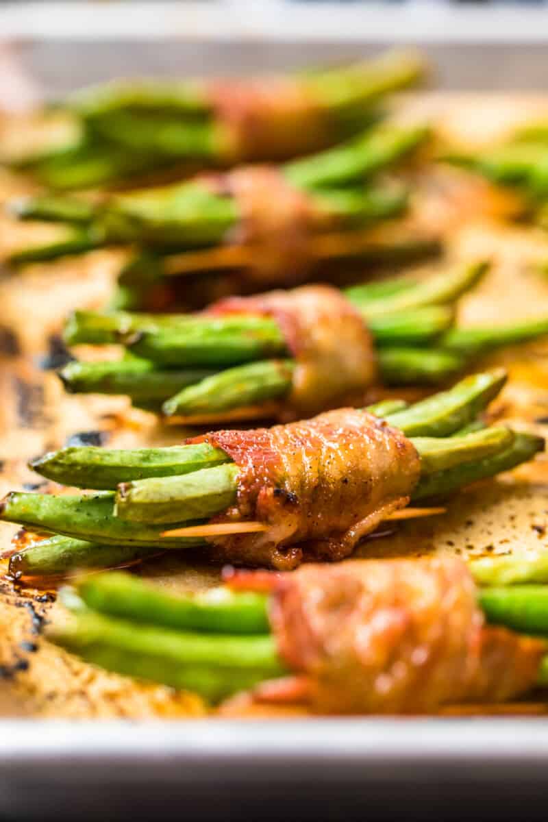 green beans wrapped in bacon on baking sheet