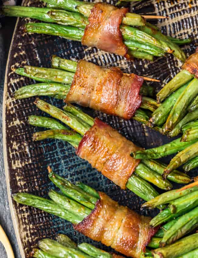 black platter with green beans wrapped in bacon