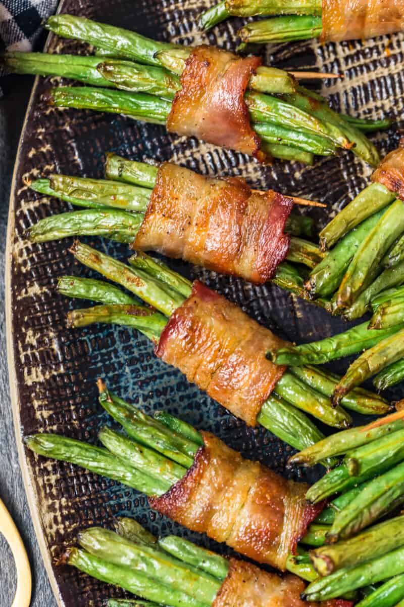 black platter with green beans wrapped in bacon