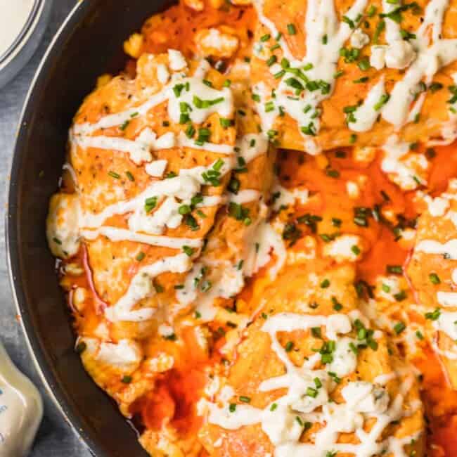 skillet with buffalo stuffed chicken topped with ranch and blue cheese