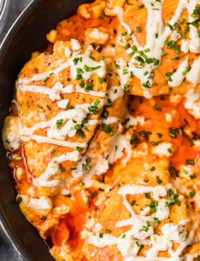 skillet with buffalo stuffed chicken topped with ranch and blue cheese