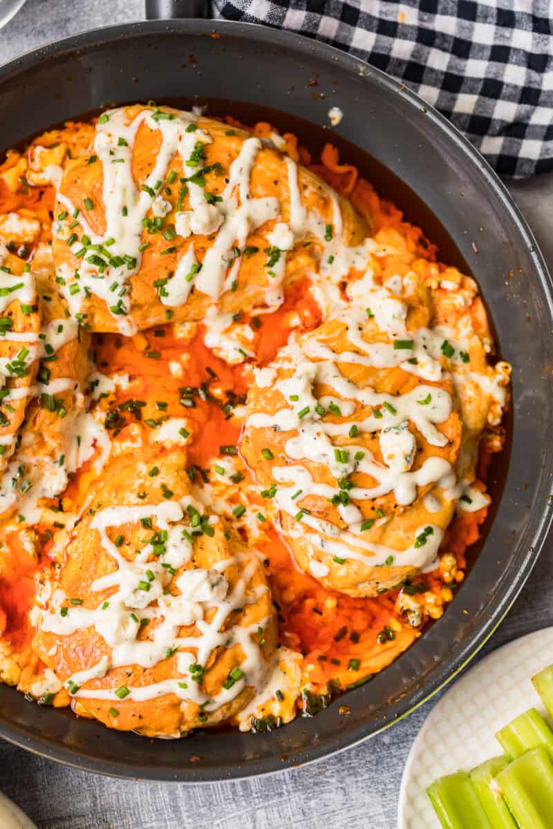 skillet with buffalo stuffed chicken topped with ranch and blue cheese