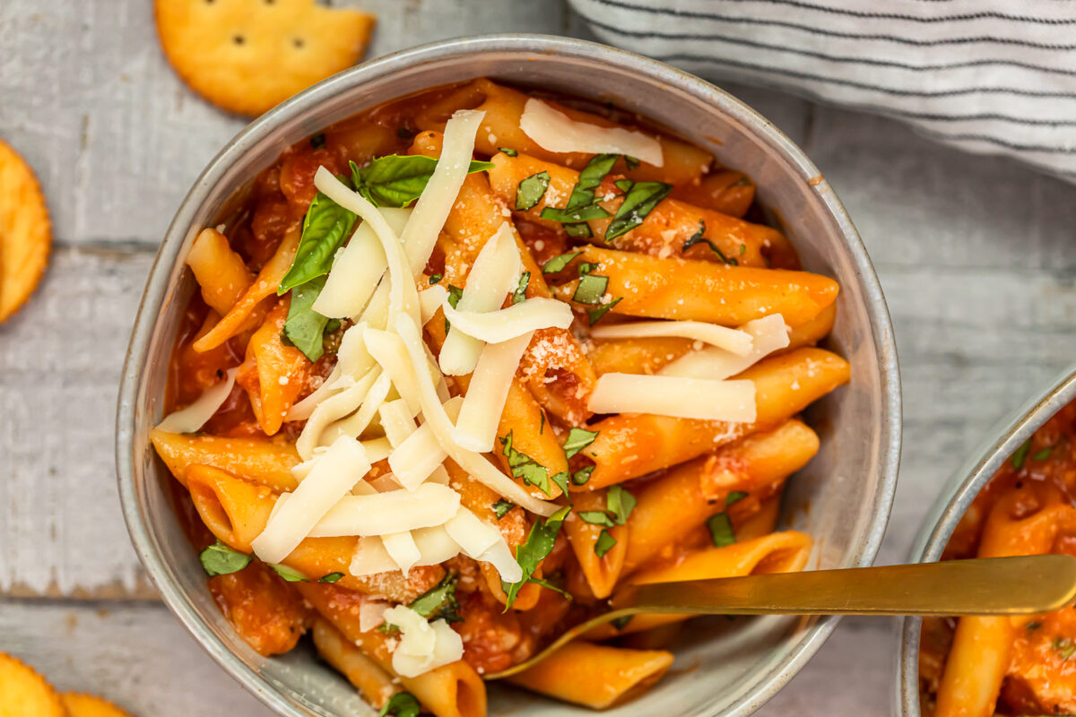 bowl of chicken parmesan soup garnished with cheese and basil