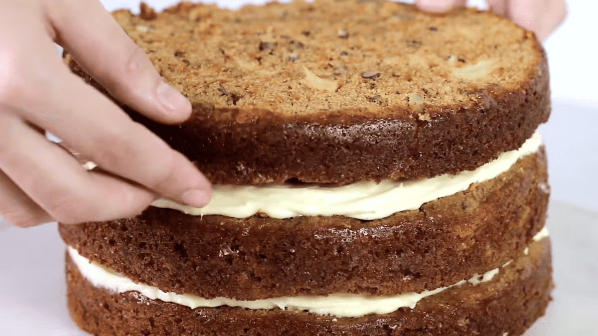 3 layers of stacked carrot cake with cream cheese frosting in between.