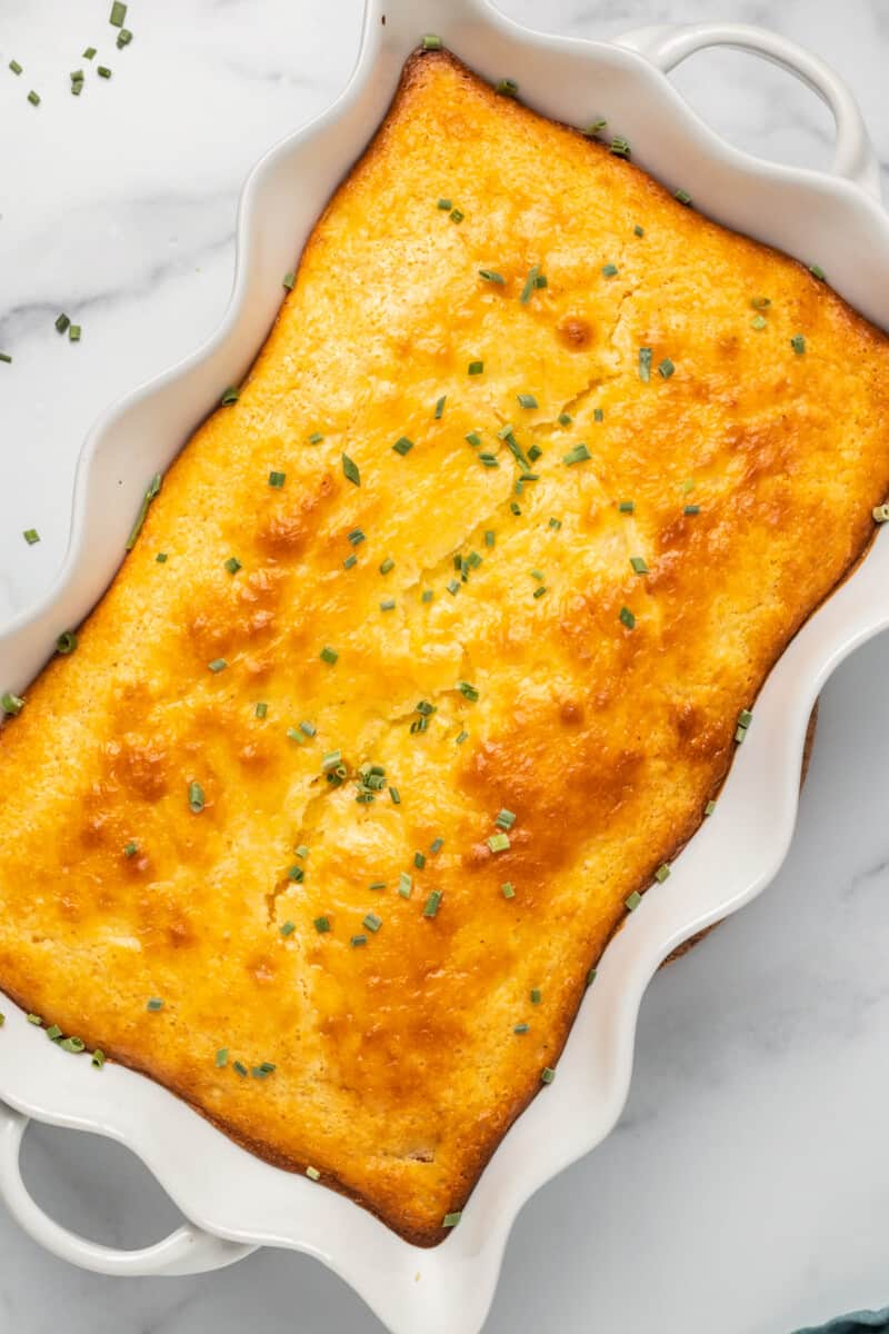 side image of loaded cornbread casserole garnished with chives