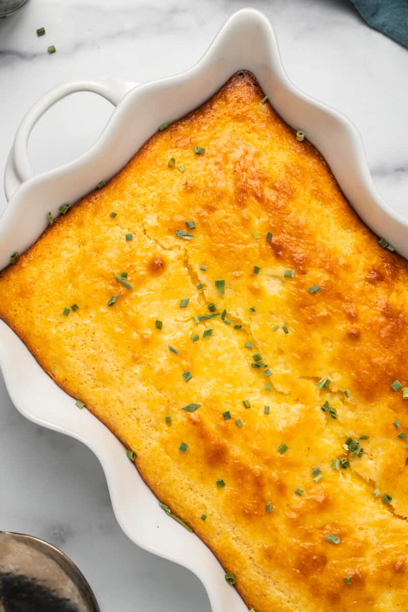 side image of loaded cornbread casserole garnished with chives