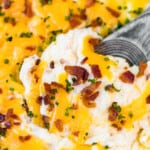 spoon digging into loaded mashed potato casserole