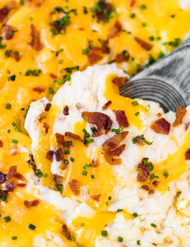 spoon digging into loaded mashed potato casserole