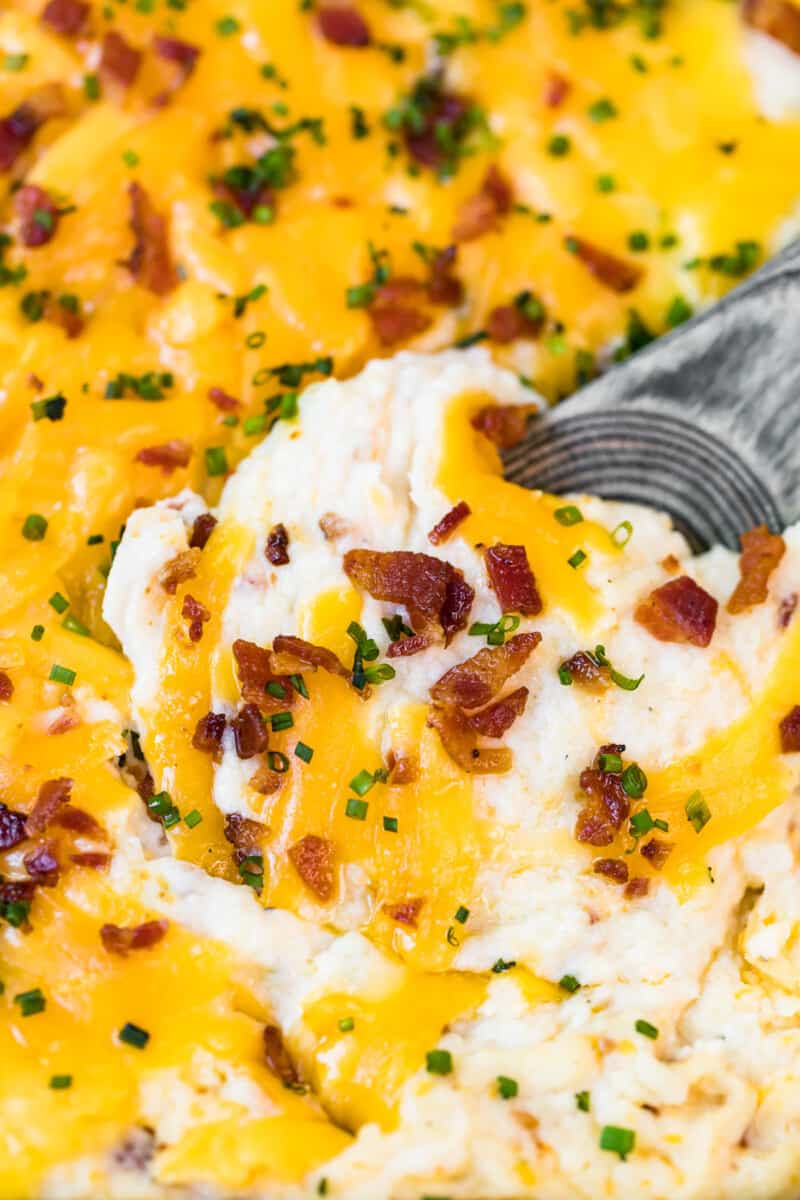 spoon digging into loaded mashed potato casserole