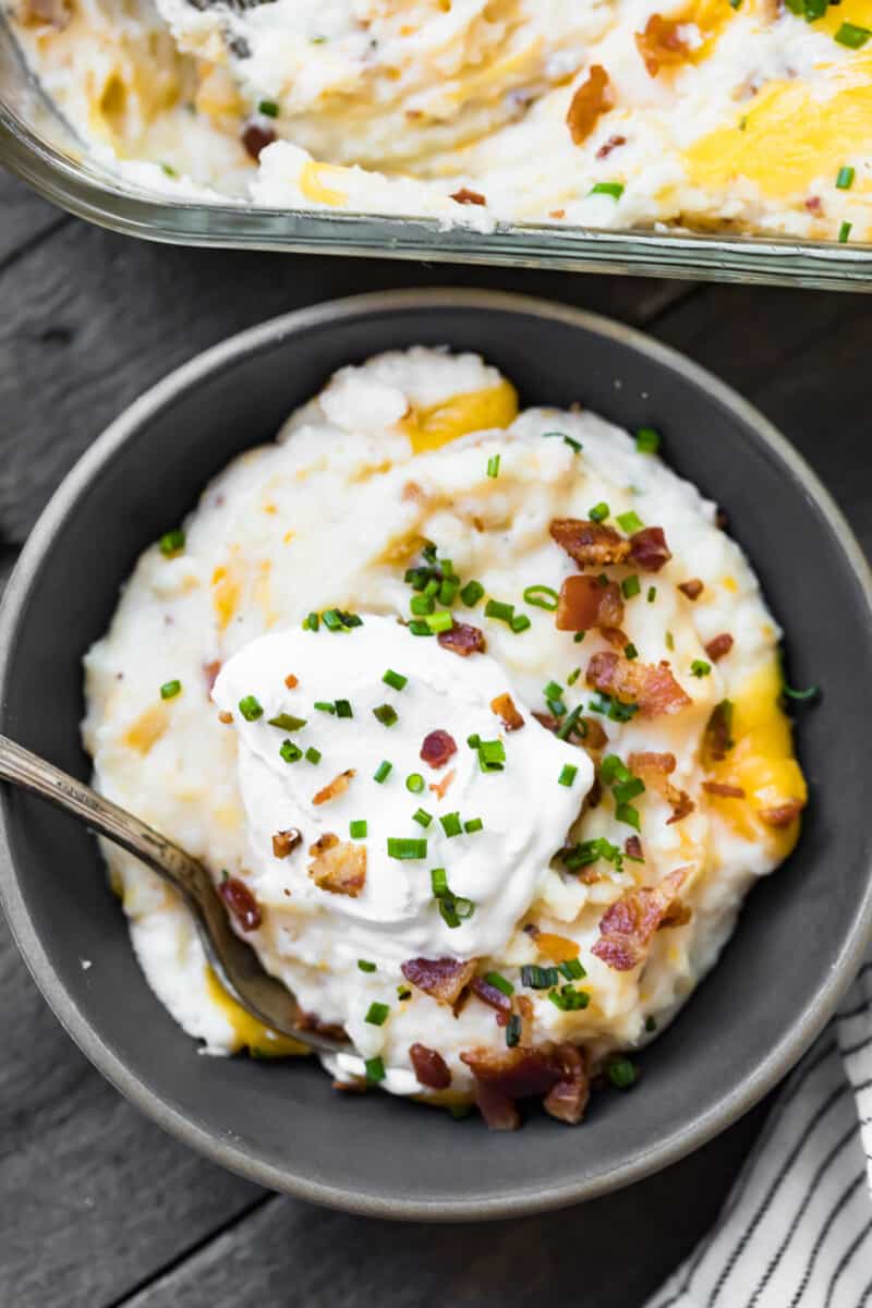 bowl of mashed potato casserole topped with sour cream