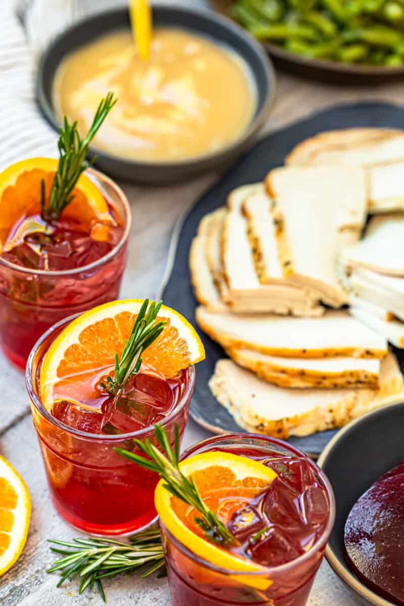 cranberry cocktails next to thanksgiving dinner