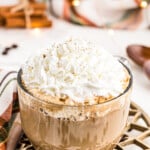 large clear mug with pumpkin spice latte topped with whipped cream