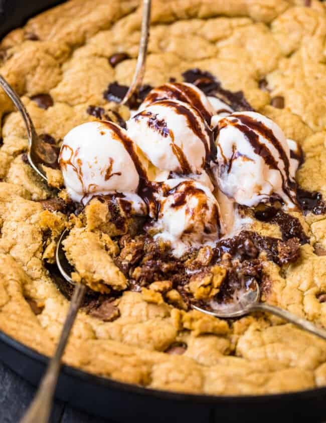 digging into skillet chocolate chip cookie with ice cream and syrup
