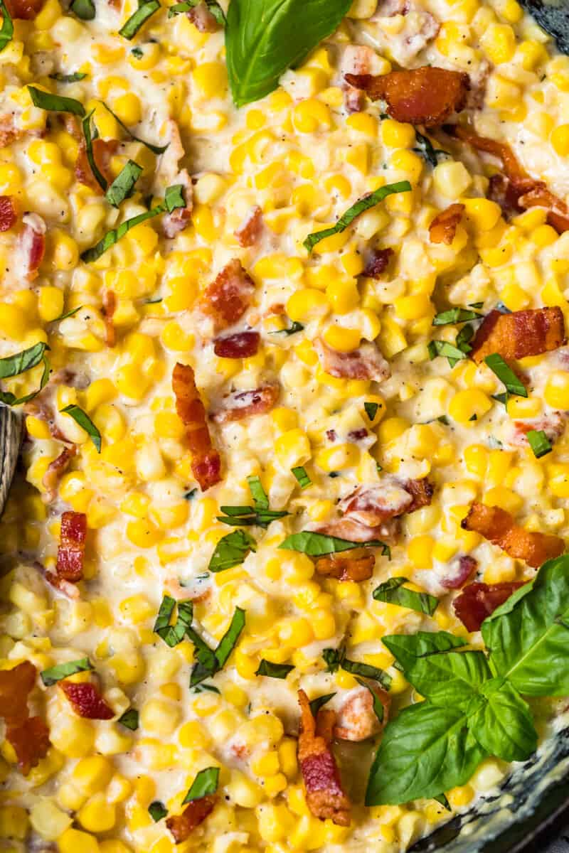 up close image of creamed corn with bacon and basil