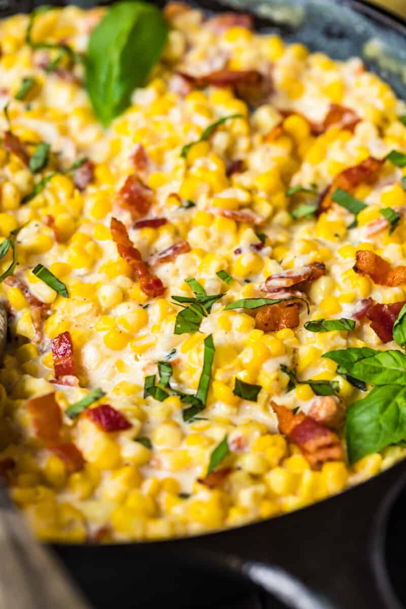 up close image of creamed corn with bacon and basil