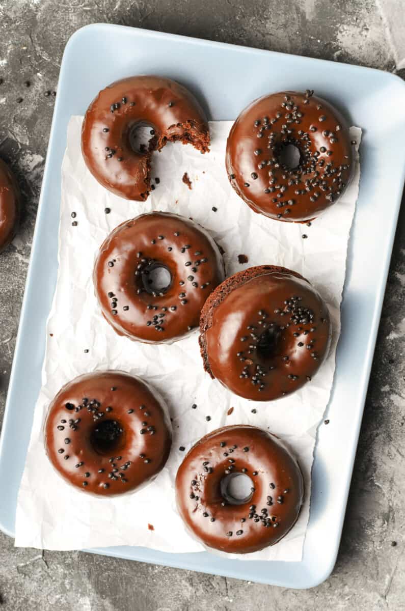 chocolate donuts on platter with parchment