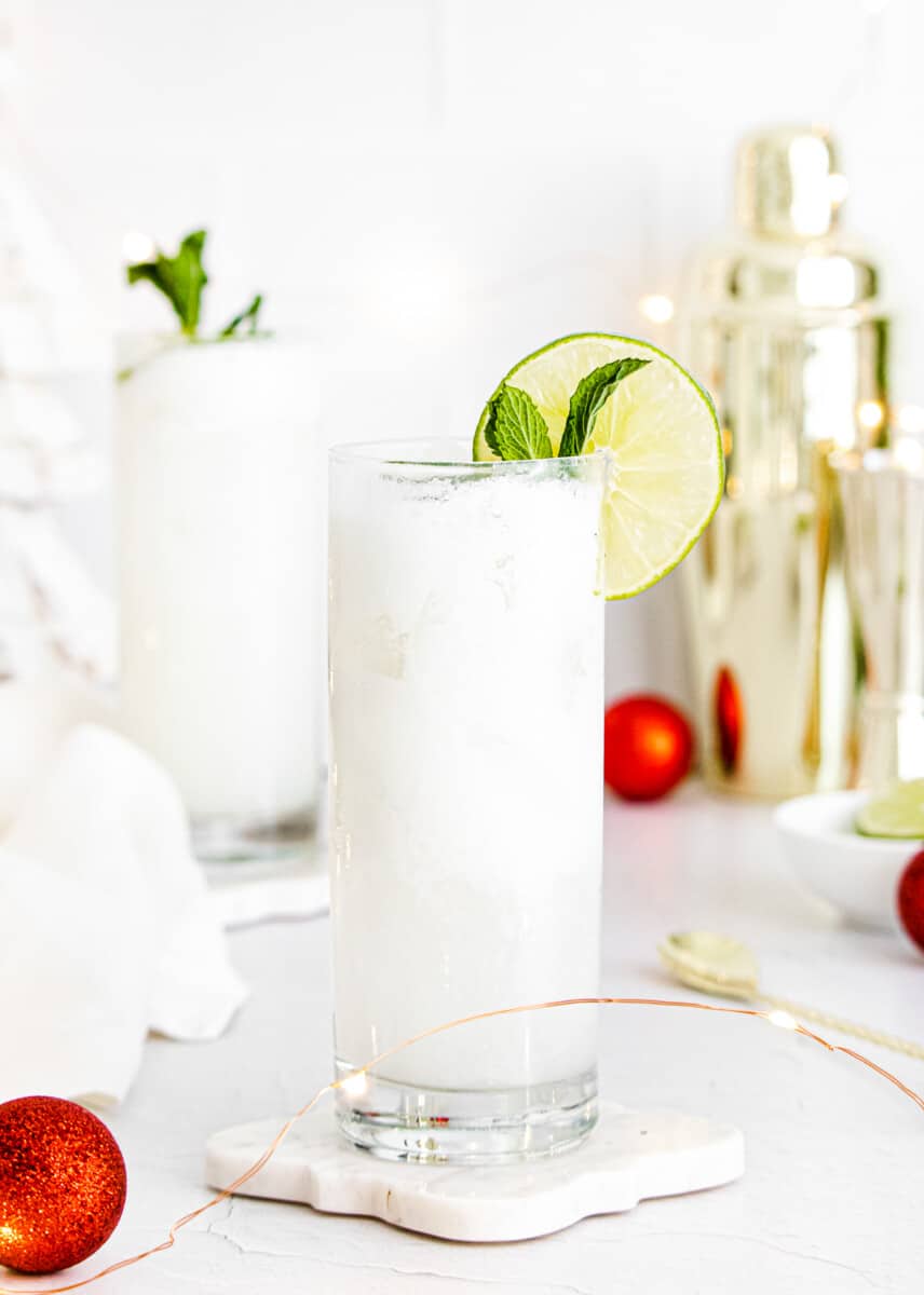 coconut mojitos garnished with lime and mint with holiday setting