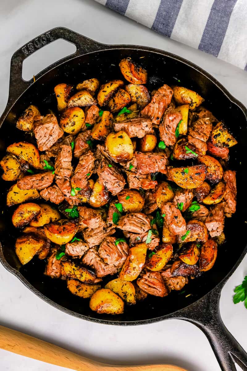 garlic steak bites with potatoes in skillet