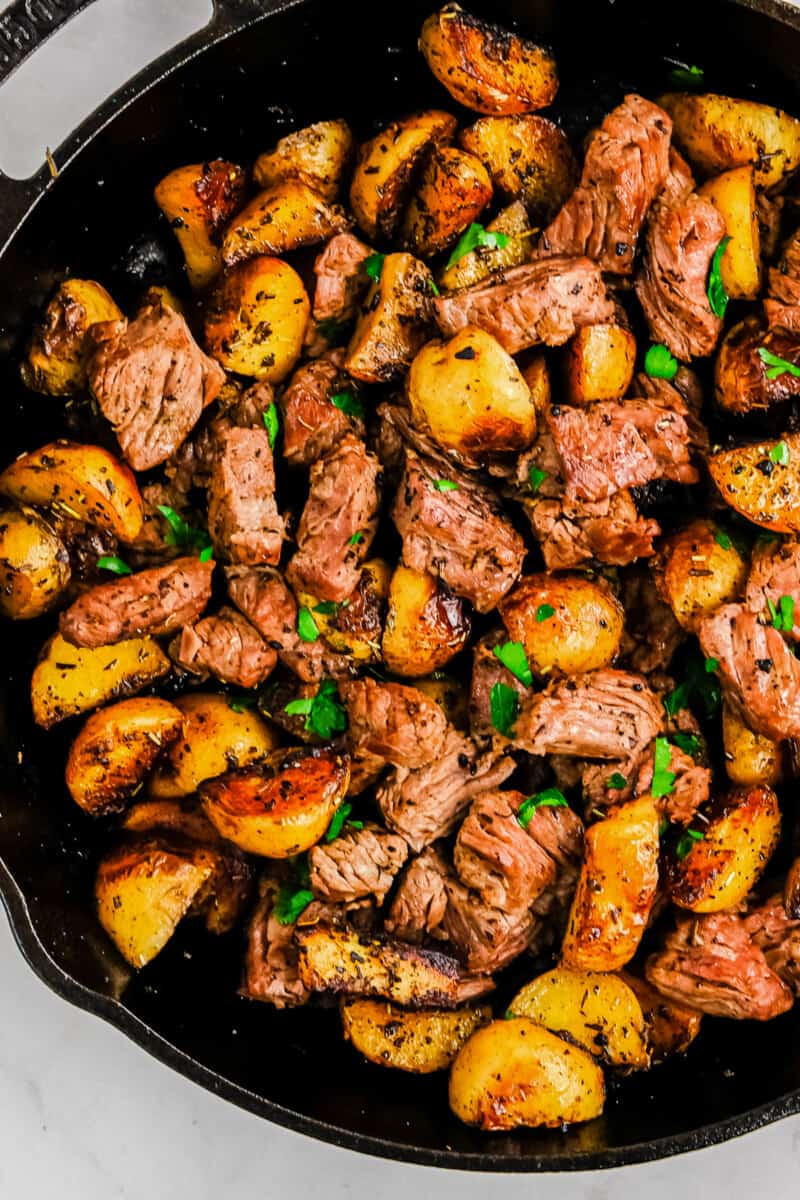 garlic steak bites with potatoes in skillet