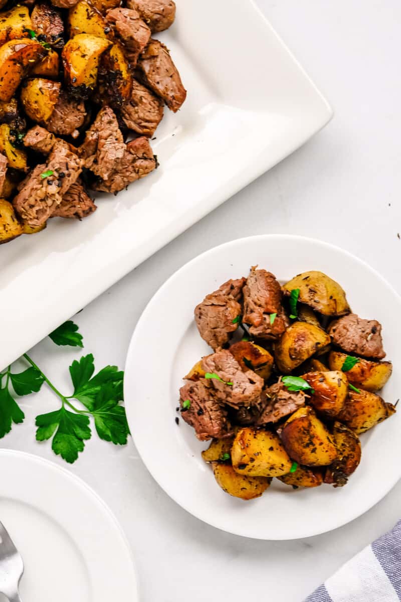 garlic steak bites with potatoes on white plate