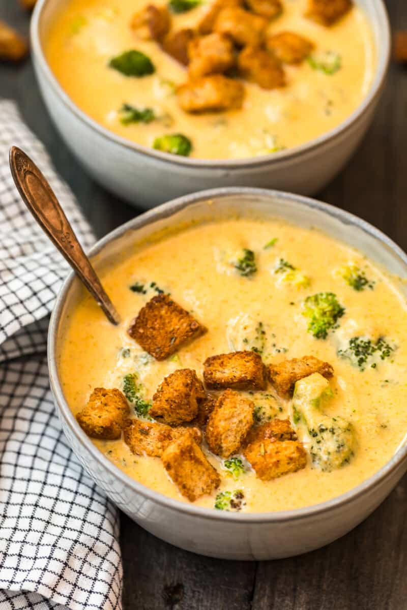 two bowls with broccoli cheese soup and croutons