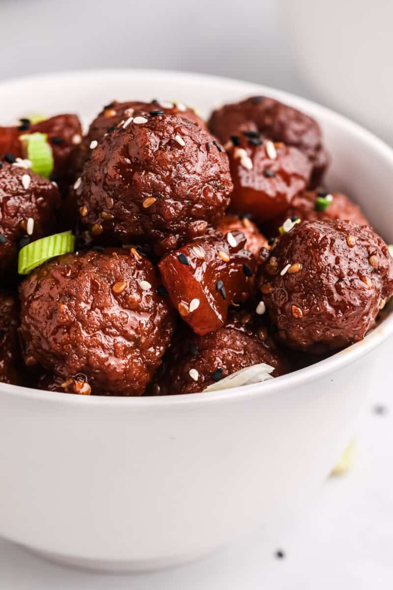 Crockpot teriyaki meatballs in white bowl.