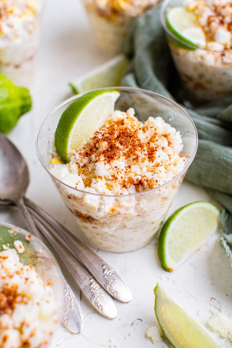 esquites in cups garnished with lime