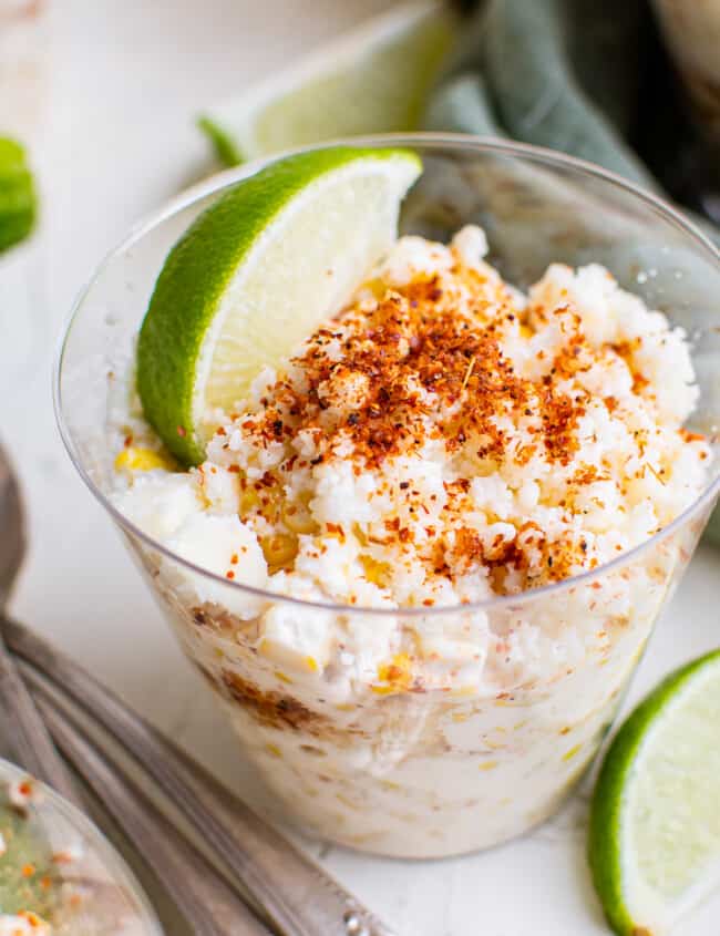 esquites in cups garnished with lime